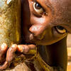 a child drinking water from a spigot