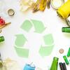 the recycle symbol, three arrows chasing one another, surrounded by items than can be recycled like glass bottles and plastic